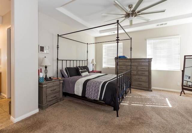 bedroom featuring a tray ceiling, ceiling fan, and light colored carpet