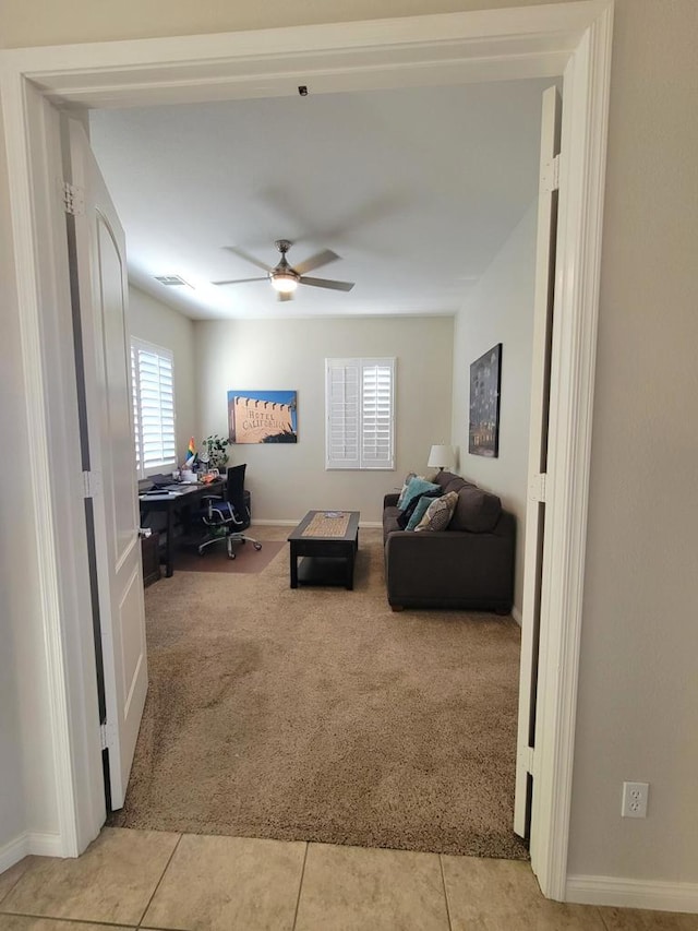 tiled living room with ceiling fan