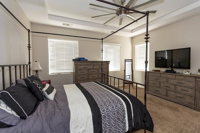 bedroom featuring carpet flooring, ceiling fan, and a tray ceiling