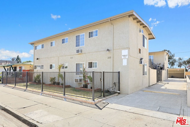 exterior space with a lawn and a wall unit AC