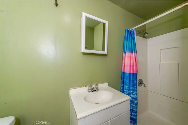 bathroom featuring walk in shower, vanity, and toilet