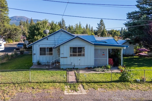 view of front of house with a mountain view and a front lawn