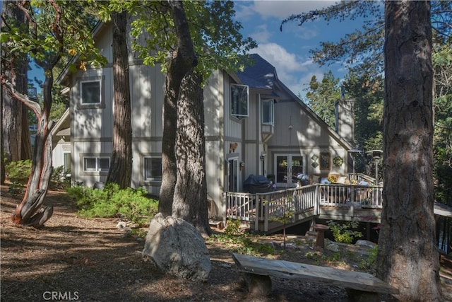 rear view of house with a deck and french doors