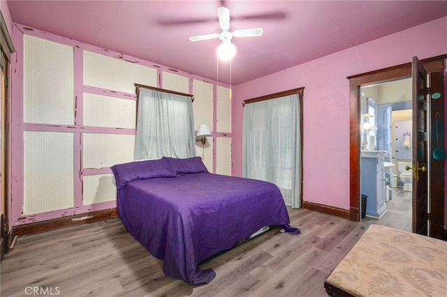 bedroom with ceiling fan, connected bathroom, and hardwood / wood-style flooring