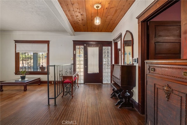 foyer entrance featuring dark wood-type flooring, wooden ceiling, and crown molding