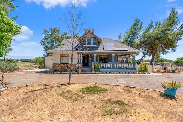 view of front of home with solar panels and a porch