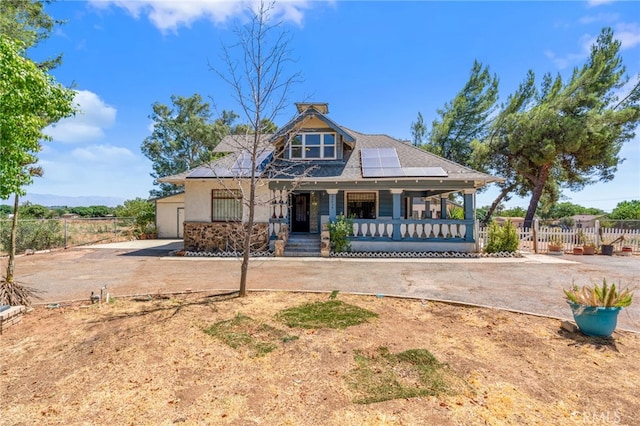 view of front of property with solar panels and a porch