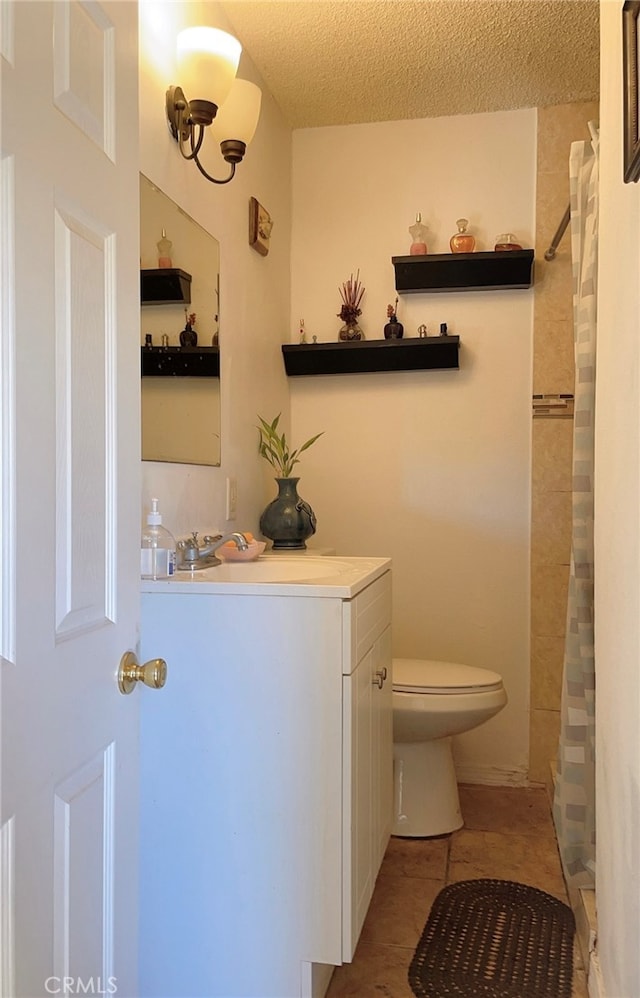 bathroom with sink, a textured ceiling, tile patterned floors, a shower with curtain, and toilet