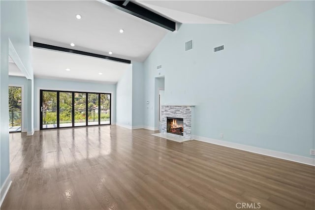 unfurnished living room featuring a fireplace, hardwood / wood-style floors, high vaulted ceiling, and beam ceiling