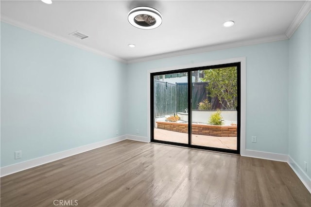 spare room with hardwood / wood-style floors and crown molding