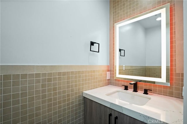 bathroom with vanity and tile walls