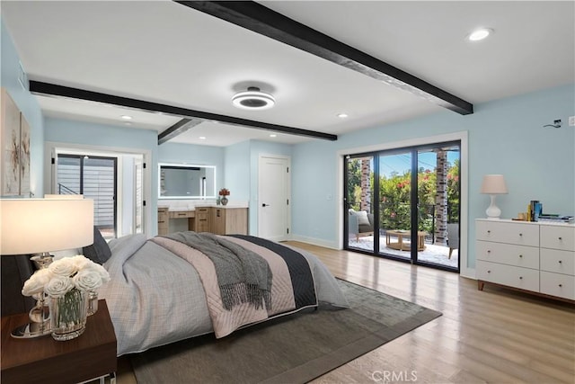 bedroom featuring beamed ceiling, light hardwood / wood-style floors, access to exterior, and ensuite bath