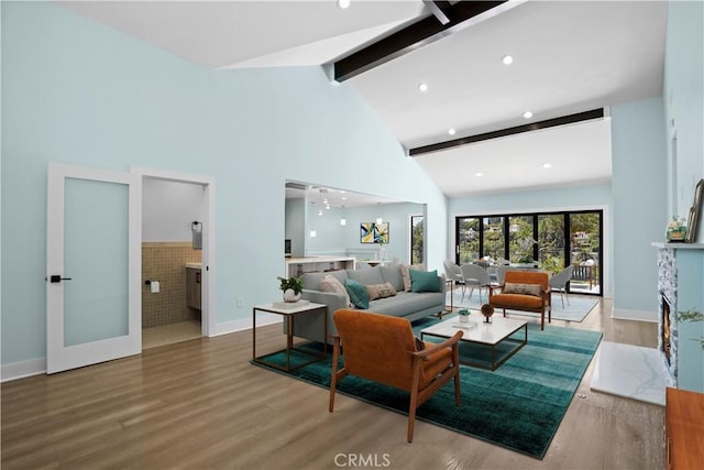 living room with beam ceiling, hardwood / wood-style flooring, high vaulted ceiling, and french doors