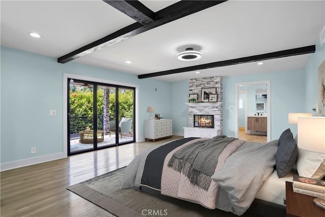 bedroom with wood-type flooring, ensuite bathroom, access to outside, and beam ceiling