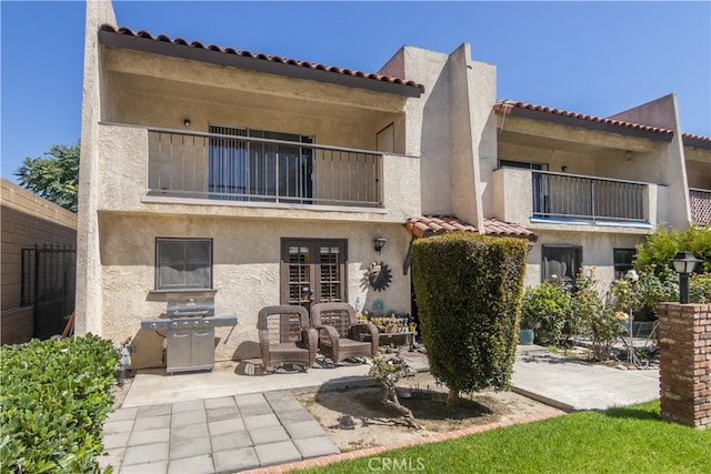 rear view of property with a balcony and a patio