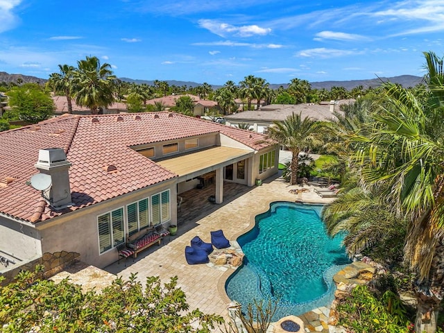 view of swimming pool with a mountain view and a patio area