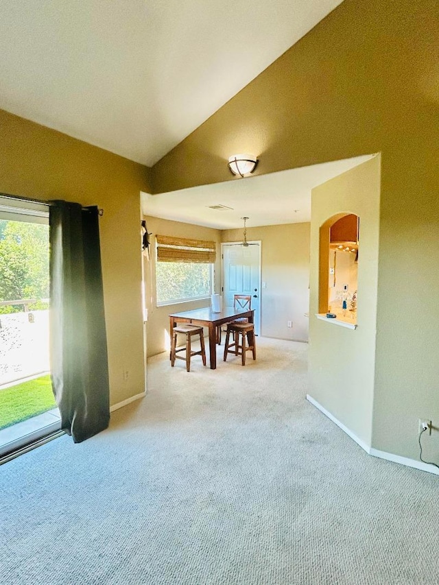 unfurnished dining area featuring carpet floors and vaulted ceiling