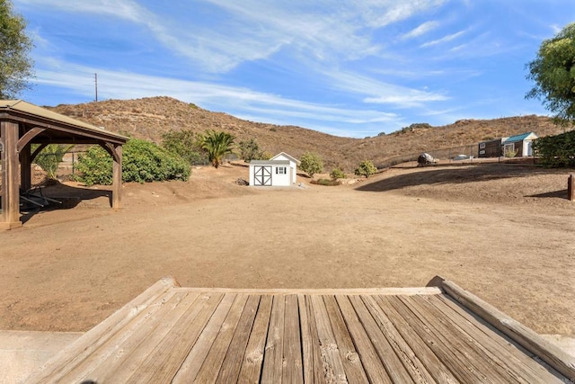 view of yard with a gazebo, a shed, and a deck with mountain view