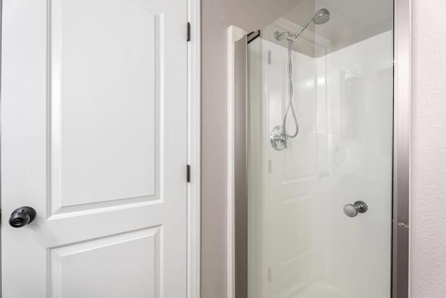 bathroom featuring a shower with shower door