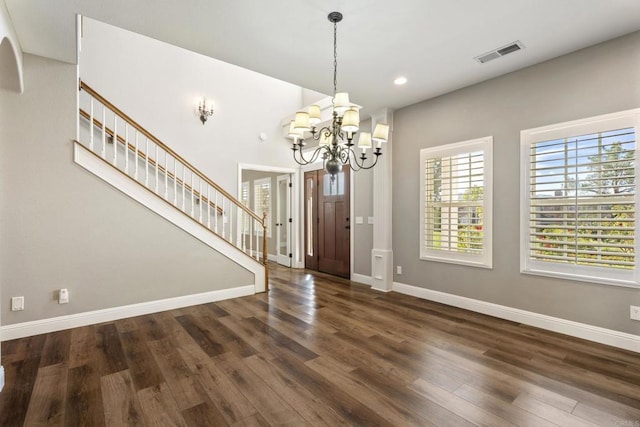 entryway with a chandelier, dark hardwood / wood-style flooring, and decorative columns