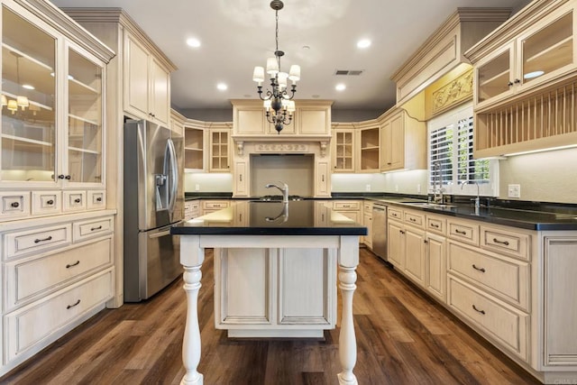 kitchen featuring pendant lighting, a kitchen island with sink, appliances with stainless steel finishes, and dark wood-type flooring