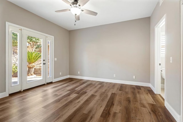 spare room with dark hardwood / wood-style flooring and ceiling fan