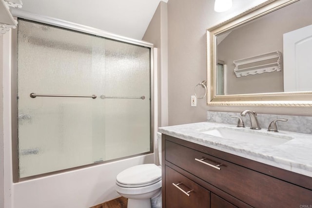 full bathroom with hardwood / wood-style floors, vanity, enclosed tub / shower combo, and toilet