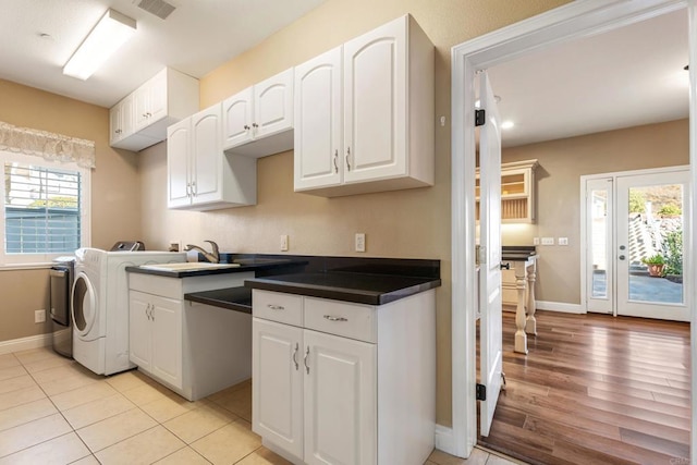 kitchen featuring separate washer and dryer, sink, white cabinets, and light wood-type flooring