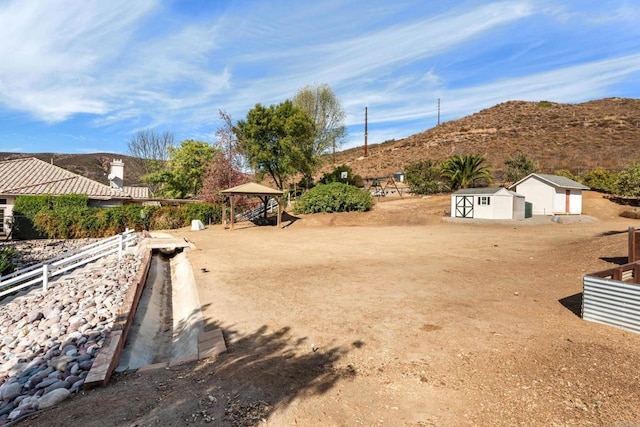 view of yard featuring a gazebo, a mountain view, and a shed