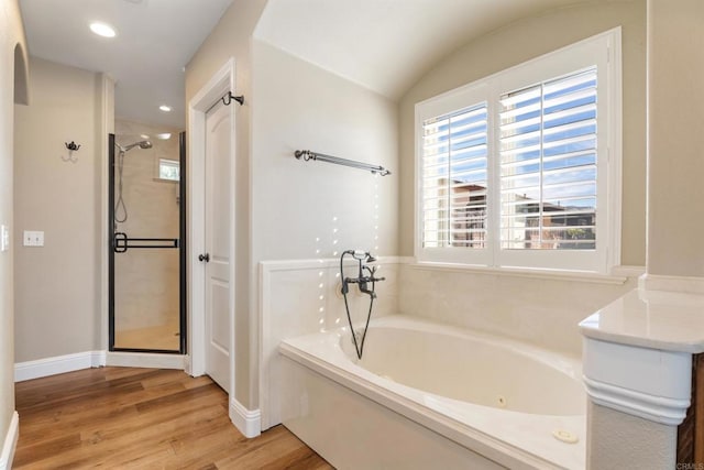 bathroom featuring lofted ceiling, shower with separate bathtub, and hardwood / wood-style flooring