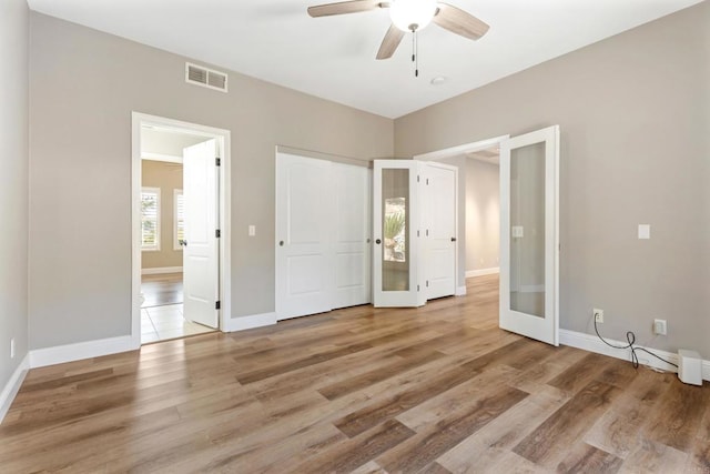 unfurnished bedroom featuring french doors, light wood-type flooring, and ceiling fan