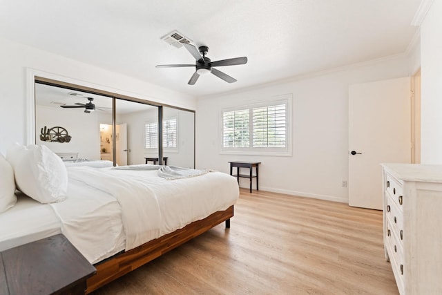 bedroom with ornamental molding, light wood-type flooring, a closet, and ceiling fan