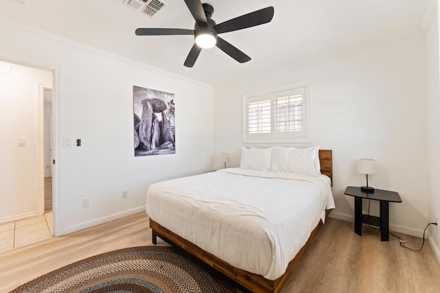 bedroom featuring ceiling fan, crown molding, and hardwood / wood-style floors