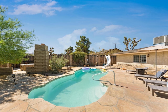 view of pool featuring a patio area, a water slide, and cooling unit