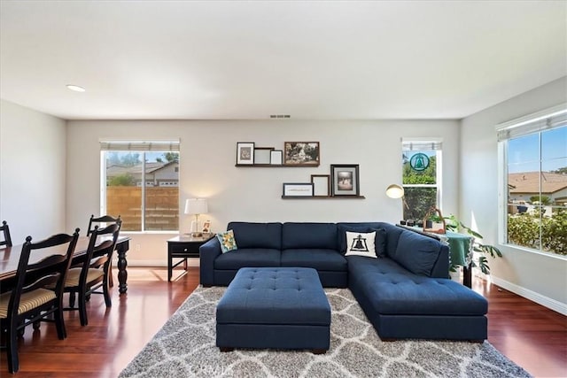 living area featuring visible vents, baseboards, and wood finished floors