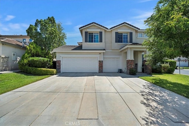 view of front of property with an attached garage, a front yard, concrete driveway, and stucco siding