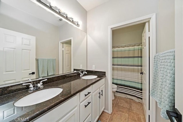 full bath featuring double vanity, tile patterned flooring, a sink, and toilet