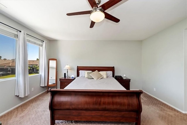 bedroom featuring light carpet, baseboards, and a ceiling fan