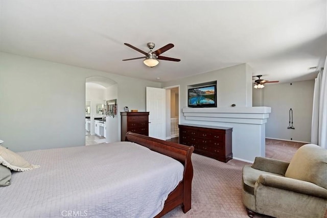 carpeted bedroom with arched walkways and a ceiling fan