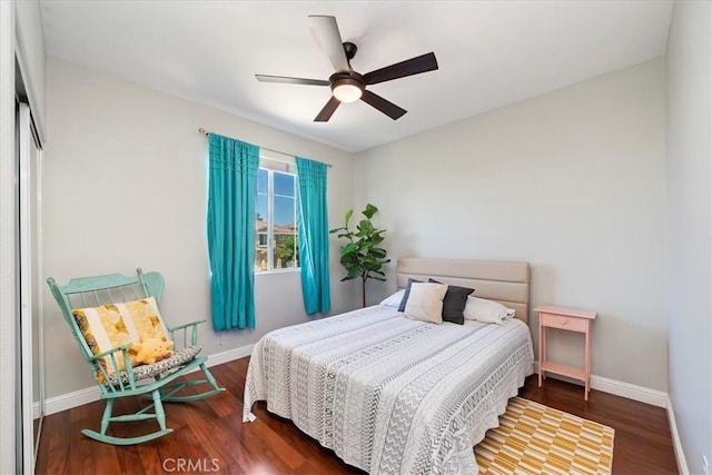 bedroom with ceiling fan, baseboards, and wood finished floors