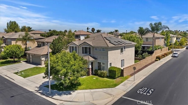 view of front of home with a garage, a residential view, concrete driveway, and a front yard