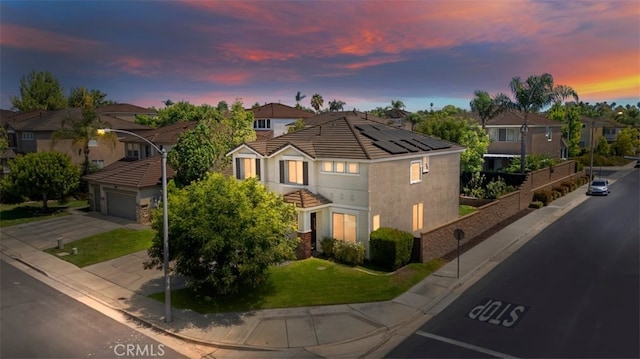 view of front facade with an attached garage, fence, concrete driveway, a residential view, and a front yard