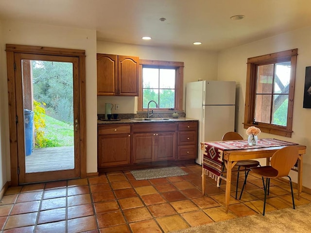 kitchen featuring tile patterned flooring, sink, and white fridge