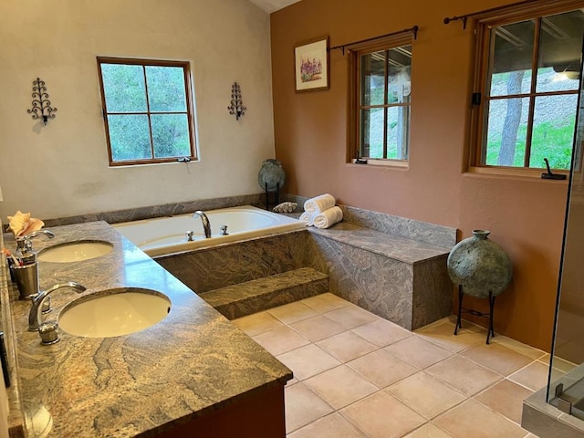 bathroom with vanity, tiled tub, and tile patterned floors