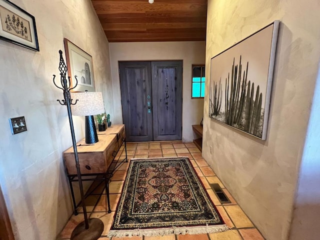 doorway featuring light tile patterned floors and wood ceiling