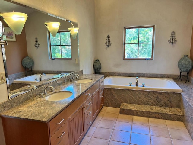 bathroom featuring a relaxing tiled tub, vanity, and tile patterned flooring