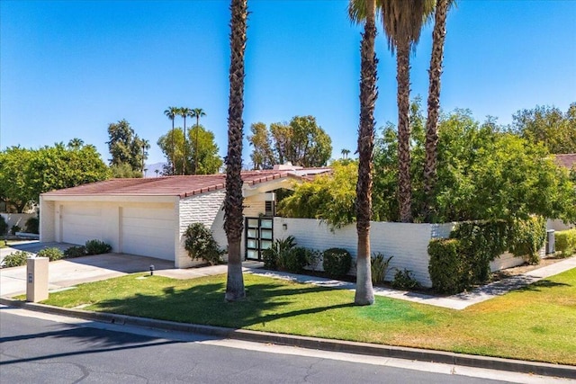 view of front of property featuring a front lawn and a garage