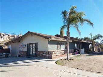 view of side of home with french doors and stucco siding
