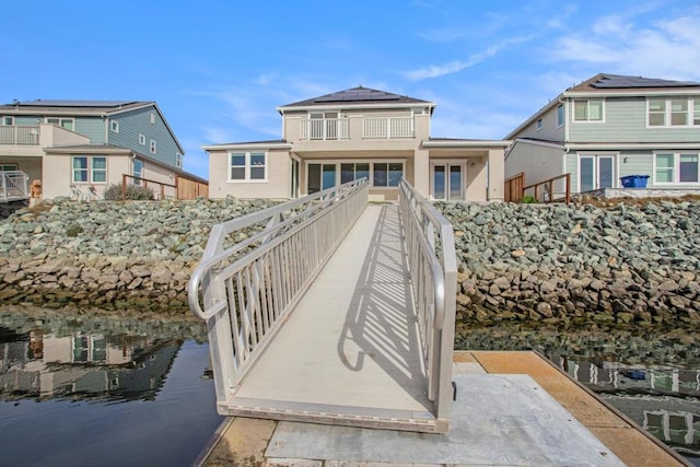 rear view of property featuring solar panels