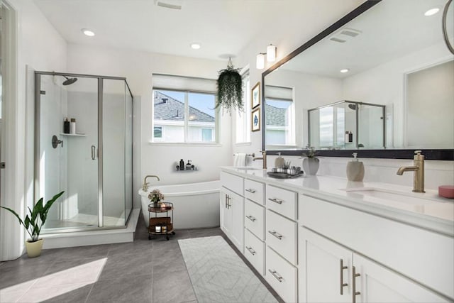 bathroom with vanity, tile patterned flooring, and plus walk in shower